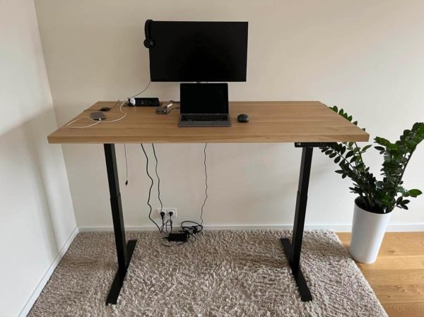 regulowane biurko dębowe z komputerem i kwiatkiem regulowane biurko dębowe z komputerem i kwiatkiem